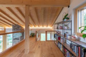 a living room with wooden ceilings and bookshelves at New chalet near Verbier ski lift in Vollèges