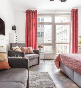 sala de estar con cortinas rojas y sofá en Charming Apartment in the City Center, en Varsovia