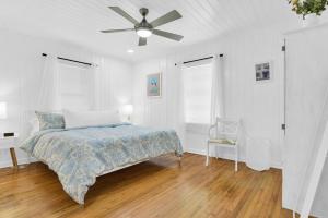 1 dormitorio blanco con 1 cama y ventilador de techo en Tranquility by the Beach, Sleeps 6, en Lake Worth