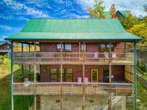 een groot houten huis met een groen dak bij Whiskey's mountain lodge, Mtn Views, Hot Tub, 560 FREE tickets each paid day in Sevierville