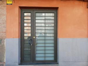 eine schwarze Tür an der Seite eines Gebäudes in der Unterkunft La Casita de Vicálvaro in Madrid