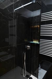 een zwarte badkamer met een douche en een wastafel bij La casa di Albert - luxury living in Milaan