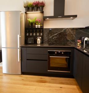 een keuken met zwarte werkbladen en een roestvrijstalen koelkast bij La casa di Albert - luxury living in Milaan