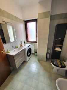 a bathroom with a sink and a washing machine at Di Gioia Home B&B in Cosenza