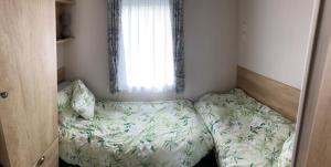 a small bed in a bedroom with a window at Sunflower Lodge, Lido Leisure Park, Knaresborough in Knaresborough