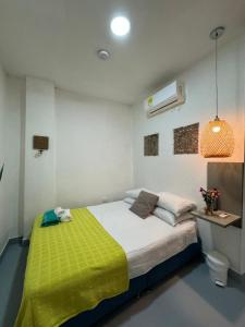 - une chambre avec un lit doté d'une couverture jaune dans l'établissement El Barrio Hostal, à Carthagène des Indes
