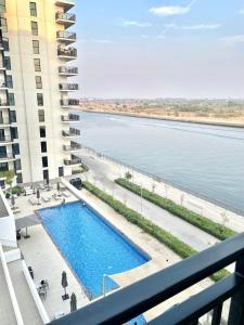 Charming Yas Island Stay with Balcony في أبوظبي: اطلالة من البلكونة على مبنى مع مسبح