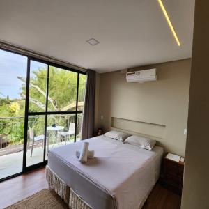 a bedroom with a bed and a large window at Casa Arrô - Pousada Boutique in Itajaí