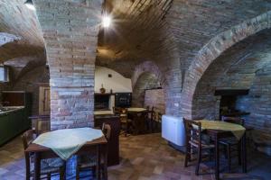 a restaurant with brick walls and tables and chairs at B&B La Locanda del Serafino in Sarnano