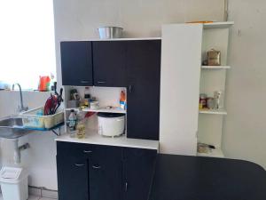 a kitchen with dark blue cabinets and a sink at Acogedora Casa en Trujillo Moche in Trujillo