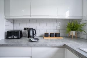 Una encimera de cocina con una tostadora y electrodomésticos encima. en Locksley House, en Knightswood