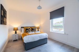 un dormitorio con una cama y una ventana en Locksley House, en Knightswood