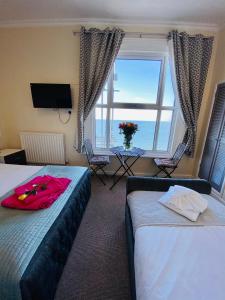 um quarto de hotel com duas camas e uma janela em Villa Mentone Hotel em Shanklin
