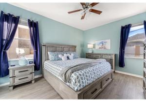 - une chambre avec un lit aux murs bleus et un ventilateur de plafond dans l'établissement 4BR Family Friendly Themed Pool Home Near Disney, à Davenport