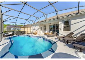 une piscine avec un toit en verre sur une terrasse dans l'établissement 4BR Family Friendly Themed Pool Home Near Disney, à Davenport