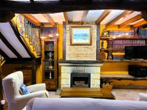 una sala de estar con chimenea y paredes amarillas. en La Casona de Picoverde en Cóbreces