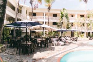 a patio with tables and chairs and umbrellas next to a pool at Luxury 2 Bedroom with Pool & Hot-tub in Santo Domingo