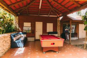 a patio with a ping pong table and a couch at Luxury 2 Bedroom with Pool & Hot-tub in Santo Domingo