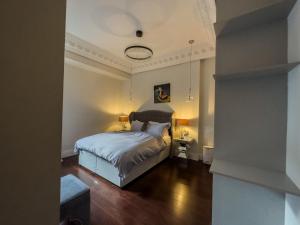 a bedroom with a bed with two lamps on it at Luxury 3 beds Palace Gate Kesington in London