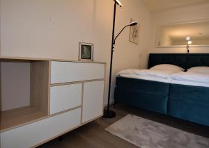 a bedroom with a bed and a dresser with a lamp at Schwieberdinger Sonnenterrassen-Wohnung in Schwieberdingen