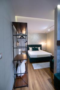 a bedroom with a bed and a room with a shelf at Melnaz Apartament 2 in Korçë