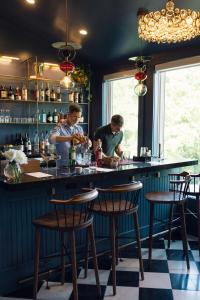 un bar avec deux hommes servant des boissons au comptoir dans l'établissement The Norumbega Inn, à Camden