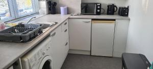 a kitchen with a sink and a washing machine at 2 Bed Flat North London in Edmonton