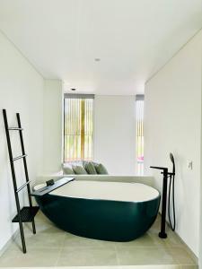 una gran bañera negra en una habitación con ventana en Lucie Villa Phu Quoc - 4 Bedroomss en Phu Quoc