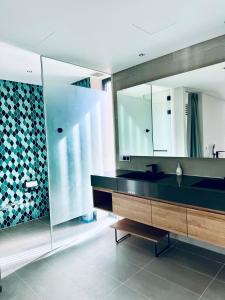 a bathroom with a sink and a large mirror at Lucie Villa Phu Quoc - 4 Bedroomss in Phú Quốc