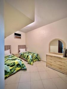 two beds in a room with a mirror and a dresser at Dar Bennis médina in Rabat