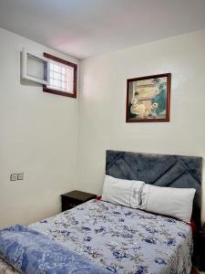 um quarto com uma cama e uma fotografia na parede em Dar Bennis médina em Rabat