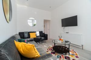 a living room with a couch and a tv at Dyke Apartment in Uddingston
