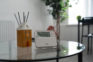 a clock sitting on top of a table with a house on it at Dyke Apartment in Uddingston