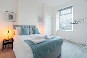 a bedroom with a large bed with towels on it at Dyke Apartment in Uddingston +8 photos