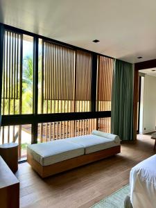 a bedroom with a bed and a large window at Lucie Villa Phu Quoc - 4 Bedroomss in Phú Quốc