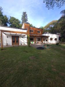 uma casa com um jardim de relva em frente em CASA ZORZAL Casaquinta en El Cazador em Belén de Escobar