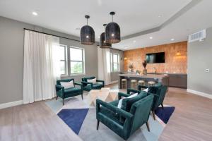 a living room with green chairs and a kitchen at Midtown Houston Luxury Suite at River Oaks in Houston