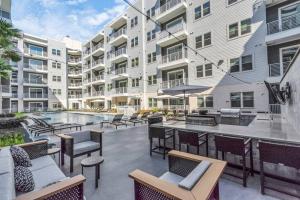a patio with chairs and a pool and a building at Midtown Houston Luxury Suite at River Oaks in Houston