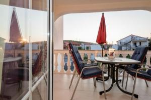 Una mesa y sillas en un balcón con vista. en Apartments Spomenka Zvonko, en Lopar