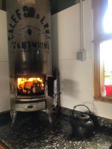 a kitchen with an oven with a fire in it at El Tranco - Casa "Bajada Poujardieu" in Junín de los Andes