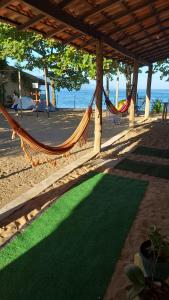 a hammock on a beach with the ocean in the background at Suite rustica in Paraty