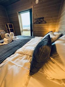 a large bed in a room with a window at Lofotenholidays, Luxury cabin with panoramic view in Leknes