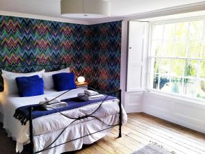 a bedroom with a bed with a colorful accent wall at Quay Street in Lostwithiel