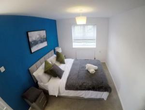 a bedroom with a large bed with a blue wall at Gorgeous 3 bed house in Bristol in Bristol