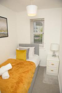 a bedroom with a large bed with yellow and white pillows at Gorgeous 3 bed house in Bristol in Bristol
