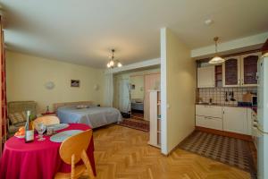 une chambre avec un lit et une table avec un tissu de table rose dans l'établissement Romeo Family Uus Apartments, à Tallinn
