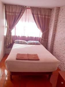 基多的住宿－Hostal El Auténtico Diamante，一间卧室设有一张大床和窗户