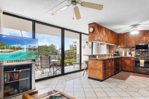 a kitchen with a view of a balcony with a tv at Maui Parkshore 209 - MCH in Kihei