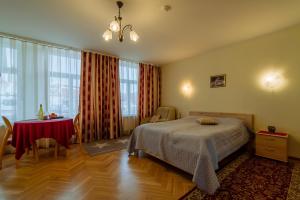 una camera con letto, tavolo e finestre di Romeo Family Uus Apartments a Tallinn