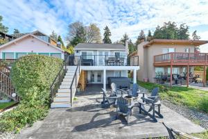 a house with a patio with chairs and a grill at Coastal PNW Home on Swimmable Beach with Hot Tub! in Stanwood